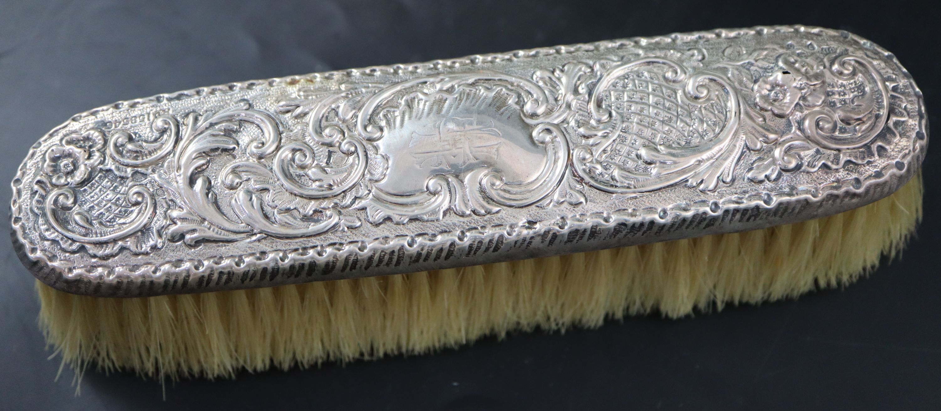 A Victorian embossed silver toilet jar, London, 1887, 93mm, 160 grams and a silver mounted clothes brush.